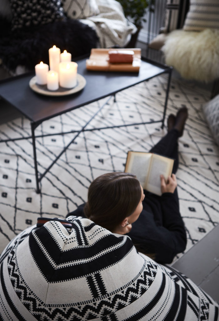 una mujer leyendo un libre en el suelo en salón en el invierno en los países nórdicos