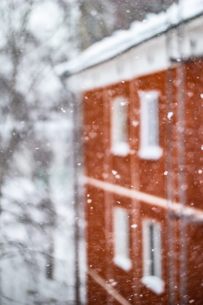 Nieve y en el fondo hay un edificio rojo