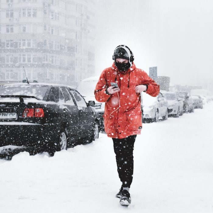El homre caminando por la calle mirando su móvil cuando nieve
